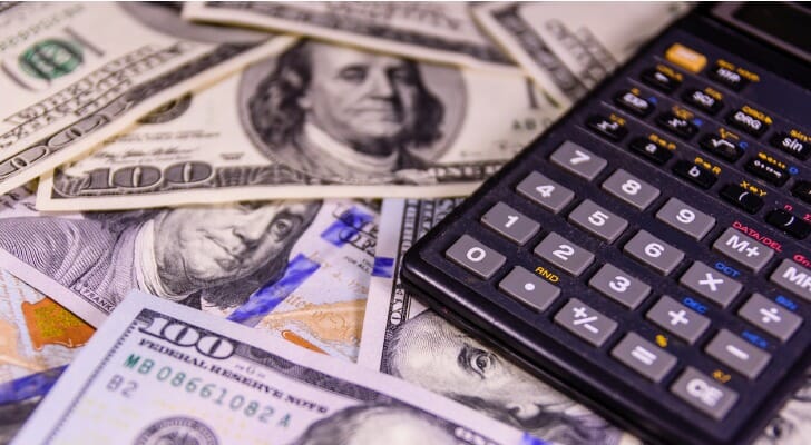 A calculator on a pile of cash.