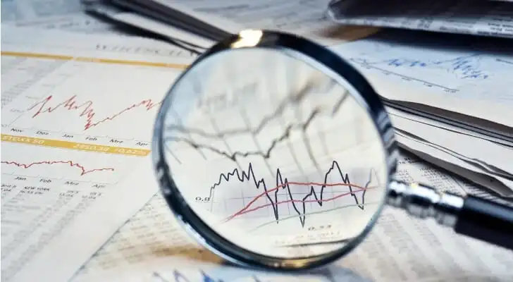 A magnifying glass highlighting a section of a finance table.