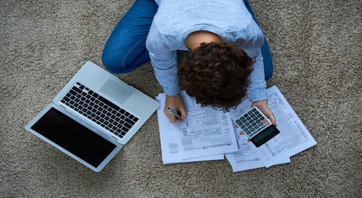 A young adult filling out tax forms.