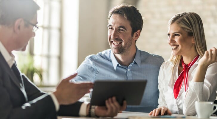 A couple discussing the net investment income tax with their financial advisor.