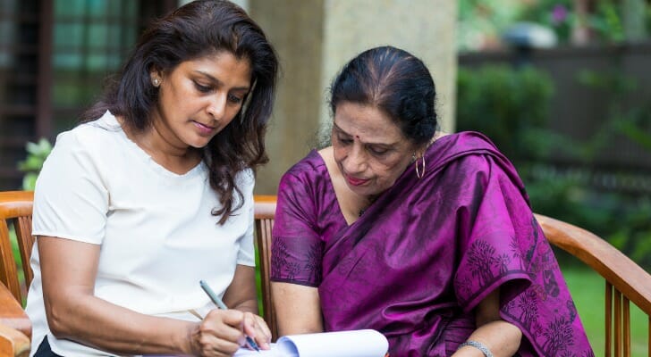 A daughter signs paperwork as the executor of trust.
