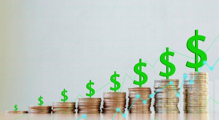 Stacks of coins lined up from shortest to tallest with green dollar signs on top of each.