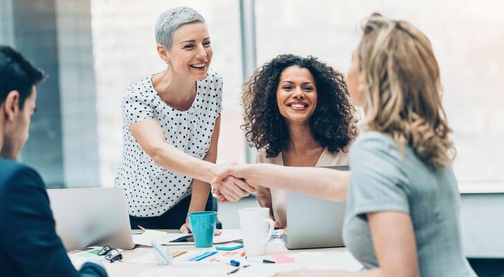 Trust company officials greet a prospective client.