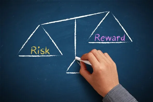 Risk-reward graphic on a chalkboard. When researching what an investment portfolio is and putting one together, it's also important to factor in your risk tolerance.