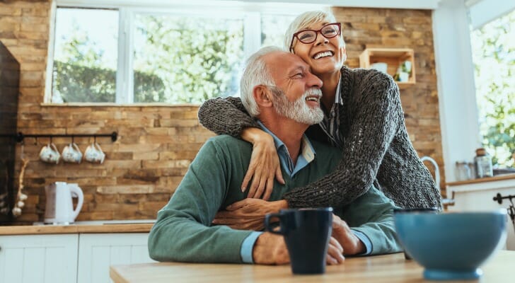 A senior couple hugging after reviewing their retirement portfolio.