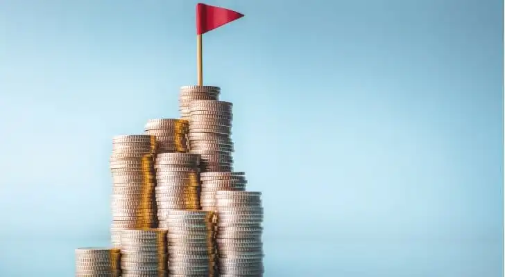 A stack of coins with a flag atop them.