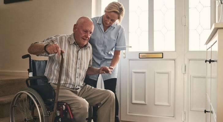 Disabled man struggles to stand up from his wheelchair