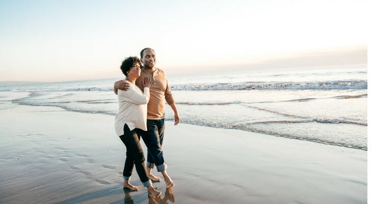 A couple walk on the beach and consider what retirement means.