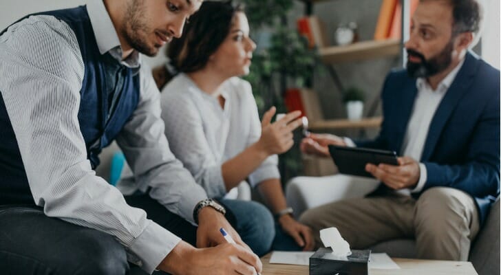 Divorcing couple discusses their case with an attorney.