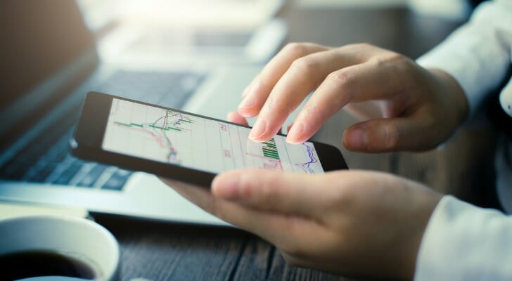 An investor reviews bond fund performance on a smart phone.