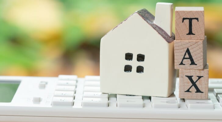 Wooden blocks reading "tax" stacked on a keyboard.