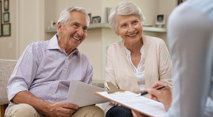 A retired couple talking with their chartered retirement planning counselor (CRPC).