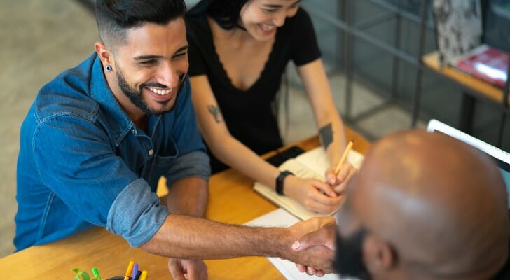 A couple meeting with a financial advisor about how to file taxes as a sole proprietor.