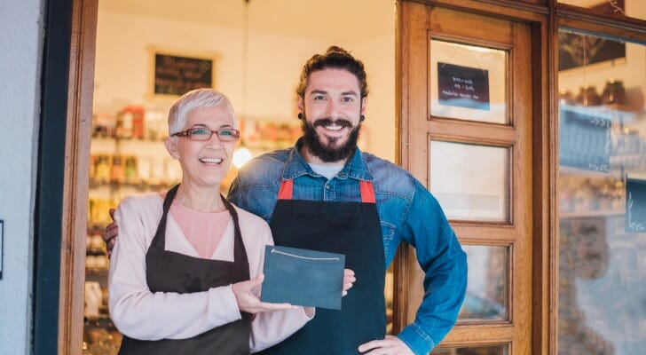 Two shopkeepers standing in front of their new business.