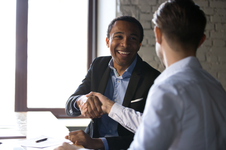 Two men shake hands over a business deal.