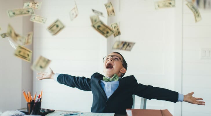 A boy throws money in the air. Both stop-loss vs. stop-limit orders can be used to help improve portfolio returns.