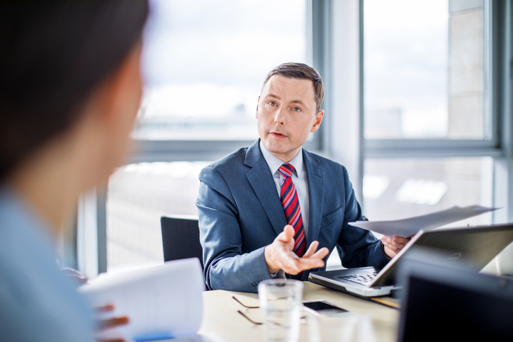 Two businessmen discuss a company's operating income vs. EBITDA.