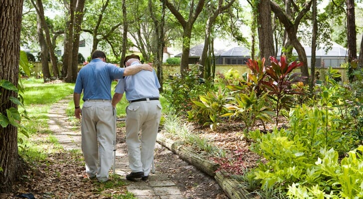 A man walks in a garden, using nursing home insurance to pay for his care.