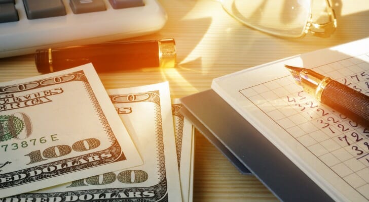 Cash and a calculator on a desk represent the need for more small business stimulus aid.