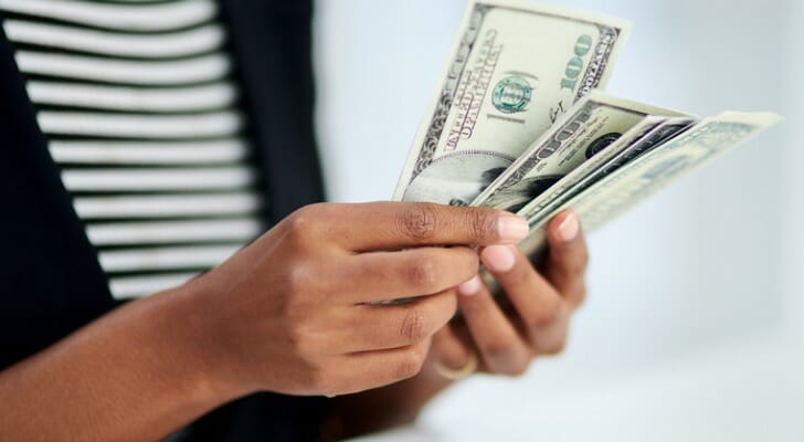A woman counting her cash represents the need for more small business stimulus relief - beyond this new bill.