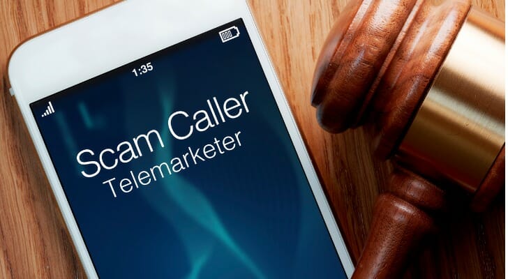 Smartphone flashing a scam alert as a call comes in