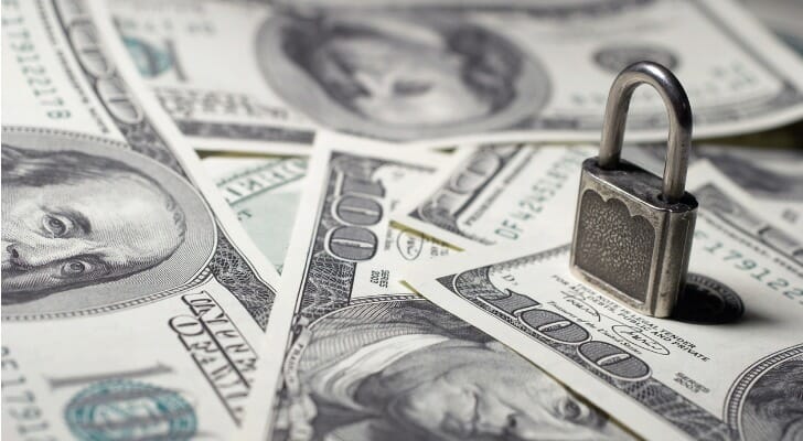 Money with a padlock on top of it