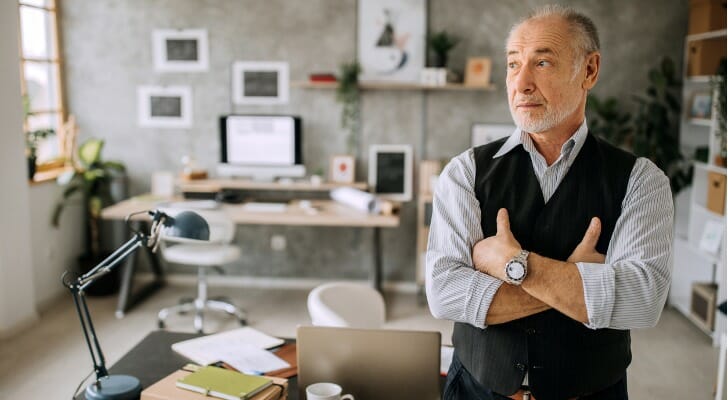 Elderly architect working in his one-man shop.