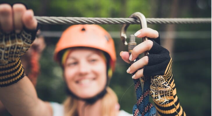 A woman reducing her risk of injury by attaching a safety harness.
