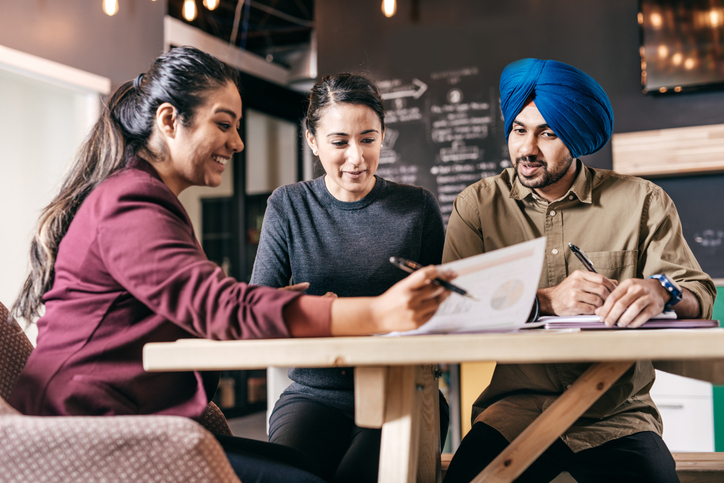 An advisor with their clients reviewing the pros and cons of alternative funds.