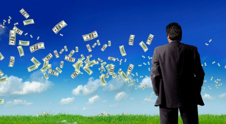 Businessman looks at green grass.