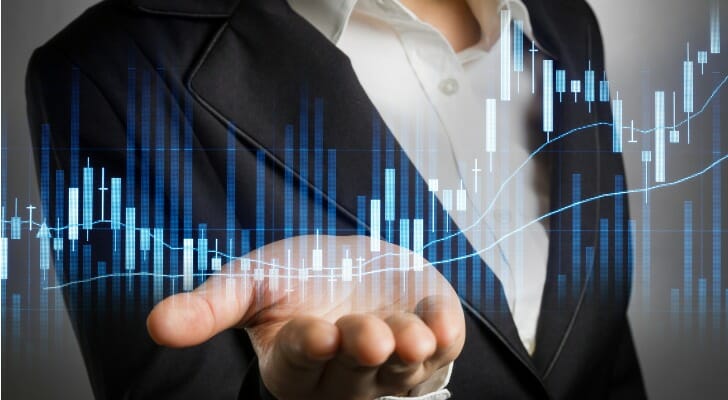 Photo of a woman holding out her hand overlaid with a candlestick chart