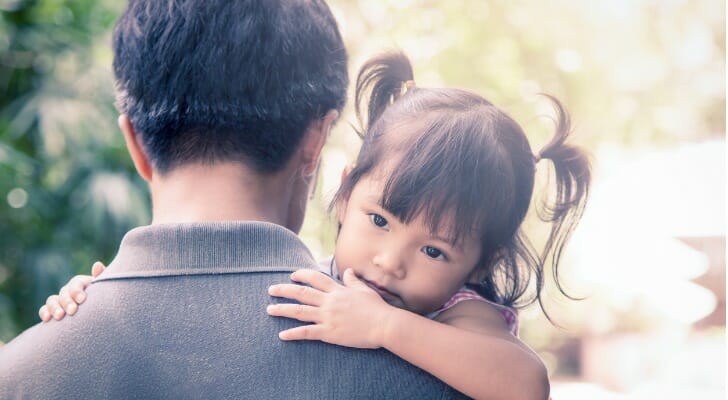 A father carries his daughter.