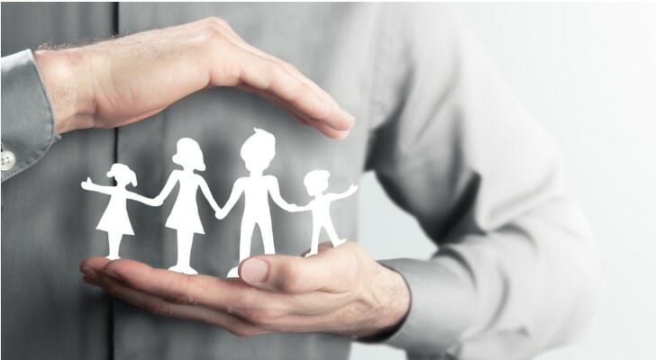 Man holding paper cutout of a family