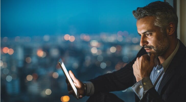 Businessman using his online trading app to invest