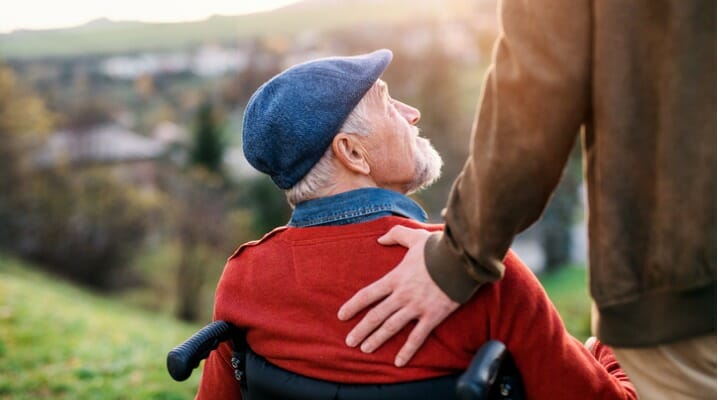 Father in a wheelchair and son outside