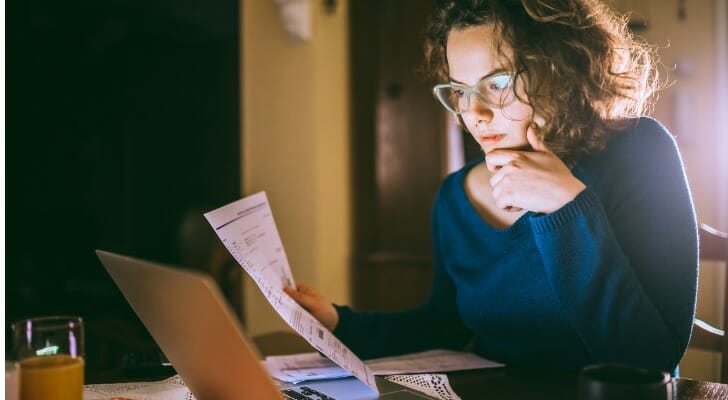 A young woman prepares a Schedule K-1 form.