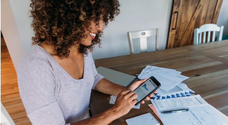 Woman using her mobile trading app