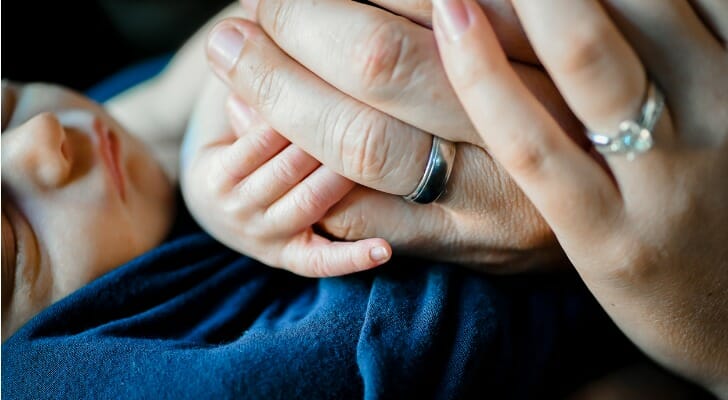 A mother holds her child, considering simple trusts vs. complex trusts for her child's future.