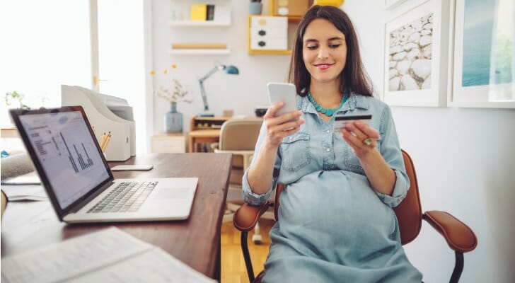 A pregnant woman checks her investments