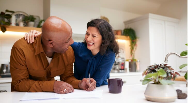 A couple in their kitchen, having decided to withdraw money from their 401(k).