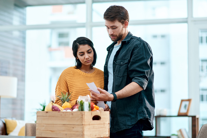 A couple consider the rising price of groceries due to inflation.