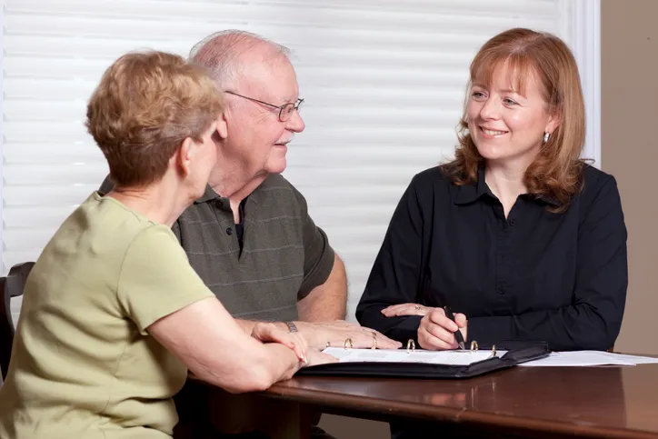 A couple discussing the pros and cons of payable on death accounts with their advisor.