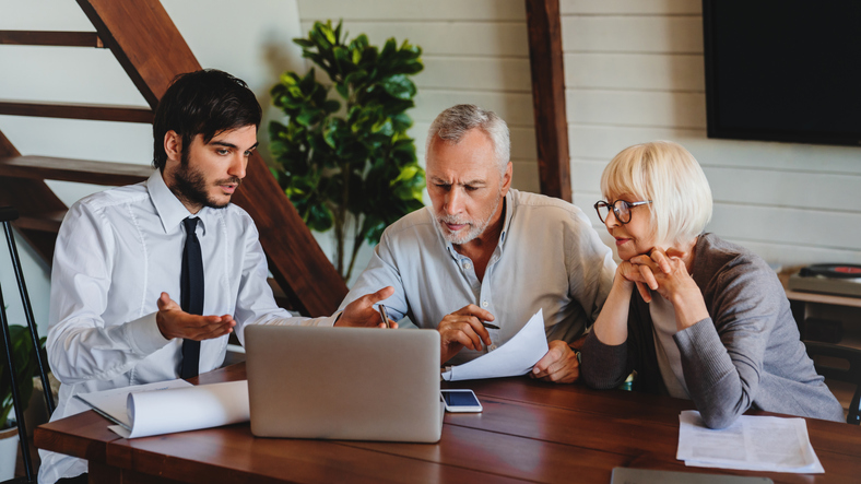 A financial advisor meets with clients to review a portfolio.