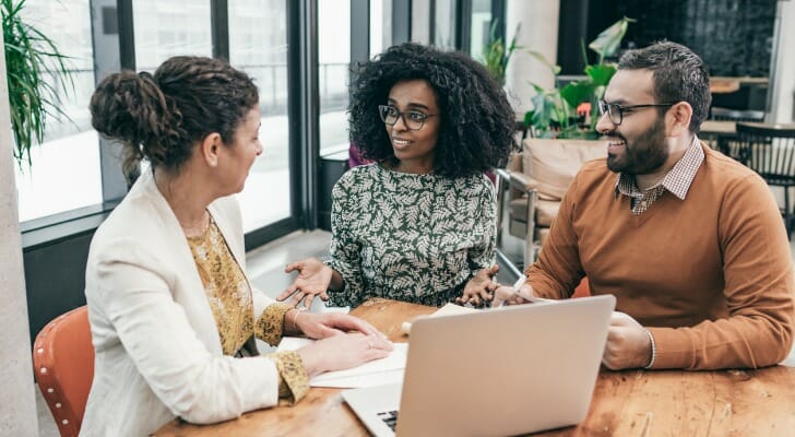 Image shows a financial advisor speaking with two potential clients. In this study, SmartAsset surveyed about 160 advisors who are part of our advisor matching platform to ask about what they see as their value proposition.