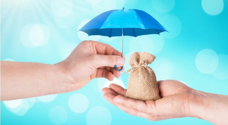 Umbrella being held over a bag of money
