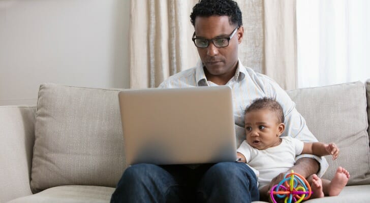 Father and son on a sofa, while the father reviews pay yourself first budgeting.