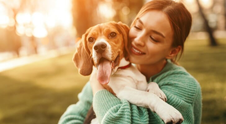 A woman embraces her dog. SmartAsset set out to find the most dog-friendly cities in the U.S.
