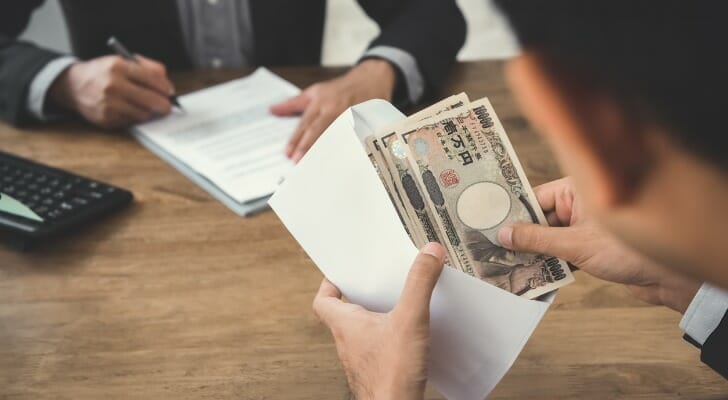 Man holding lots of Japanese yen bills