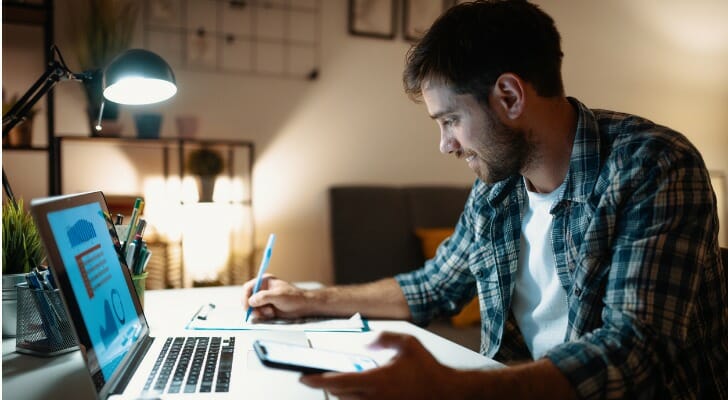 A man trades cryptocurrency from his home computer. The $1 trillion federal infrastructure bill aims to change how transactions are reported.