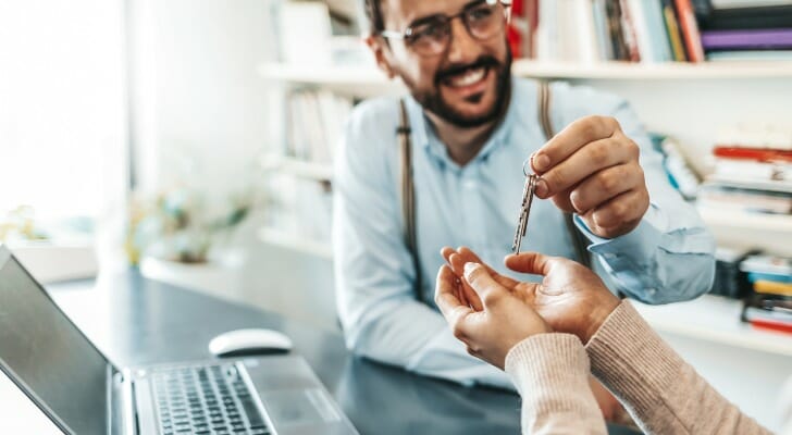 Real estate agent handing keys to buyer. A deed transfers property ownership from a seller to a buyer.